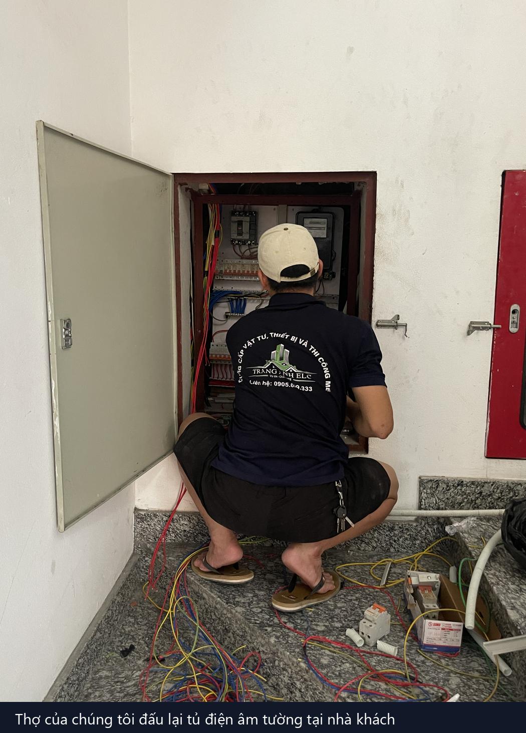 thợ sửa điện tại nhà đang đấu dây trong tủ điện âm tường