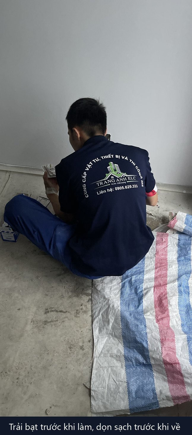 thợ điện trải bạt ngồi đấu dây trong nhà khách